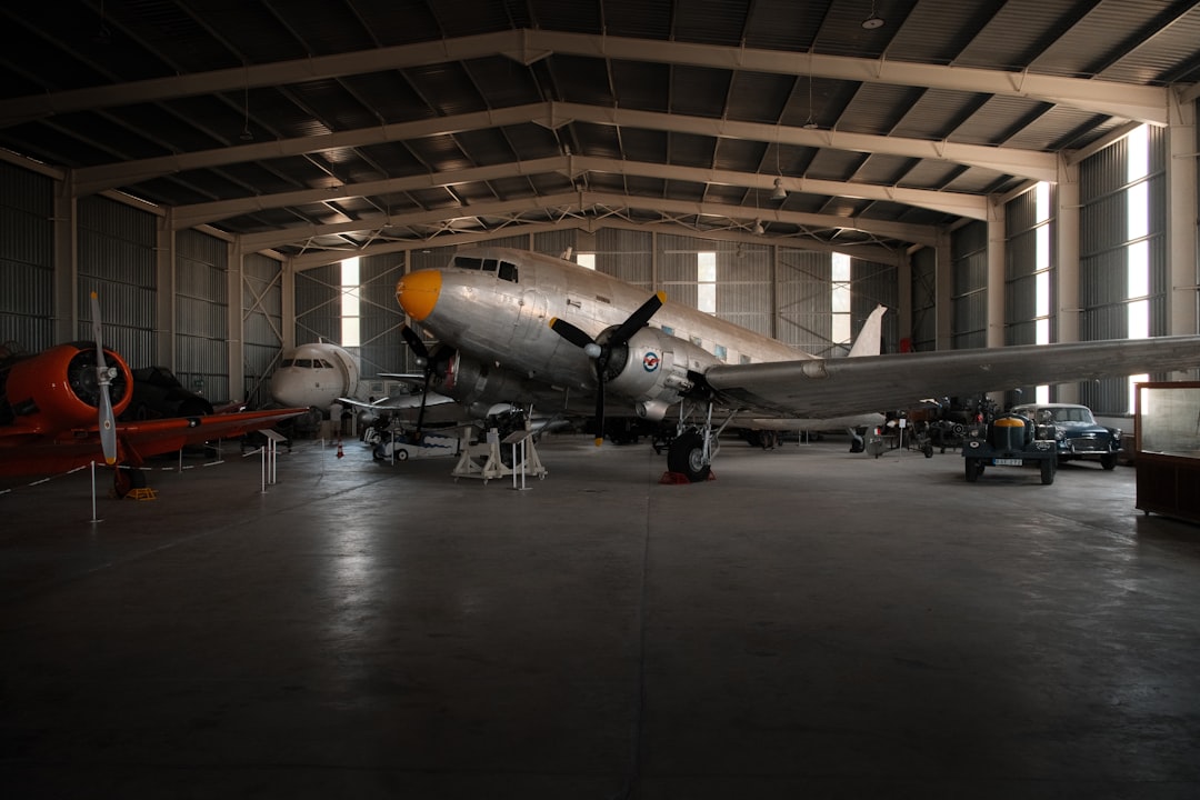 Wide aircraft maintenance hangar interior where FOD tape zone markings are applied and maintained